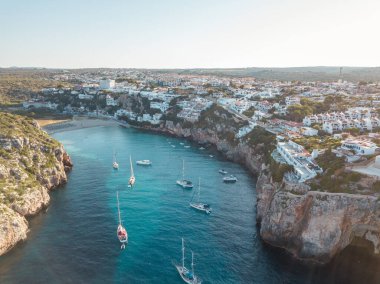 Akdeniz 'de turkuaz safirli sularla dolu tropikal plaja yanaşmış bir teknenin kuş bakışı dronu.