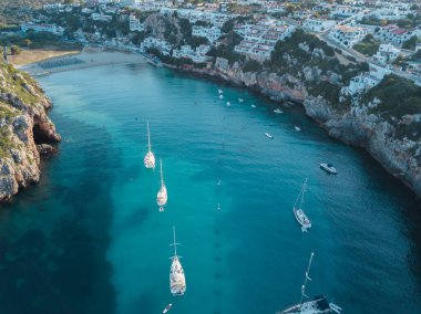 Akdeniz 'de turkuaz safirli sularla dolu tropikal plaja yanaşmış bir teknenin kuş bakışı dronu.