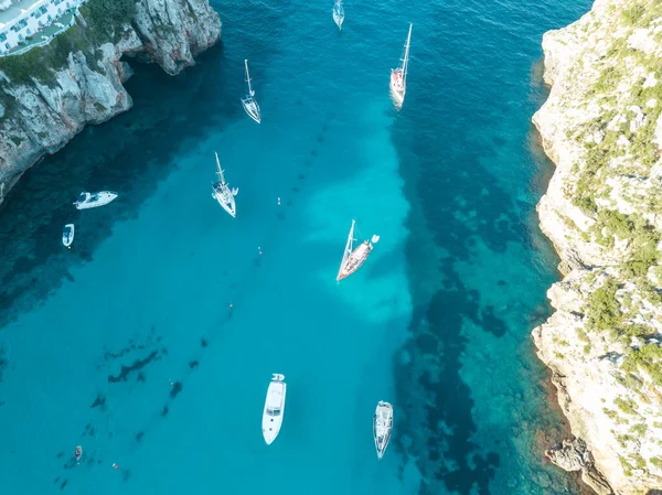Akdeniz 'de turkuaz safirli sularla dolu tropikal plaja yanaşmış bir teknenin kuş bakışı dronu.