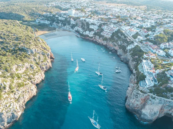 Akdeniz 'de turkuaz safirli sularla dolu tropikal plaja yanaşmış bir teknenin kuş bakışı dronu.