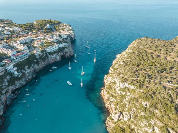 Akdeniz 'de turkuaz safirli sularla dolu tropikal plaja yanaşmış bir teknenin kuş bakışı dronu.