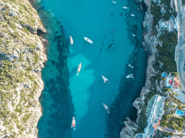Akdeniz 'de turkuaz safirli sularla dolu tropikal plaja yanaşmış bir teknenin kuş bakışı dronu.