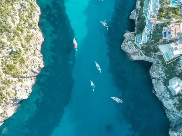 Akdeniz 'de turkuaz safirli sularla dolu tropikal plaja yanaşmış bir teknenin kuş bakışı dronu.