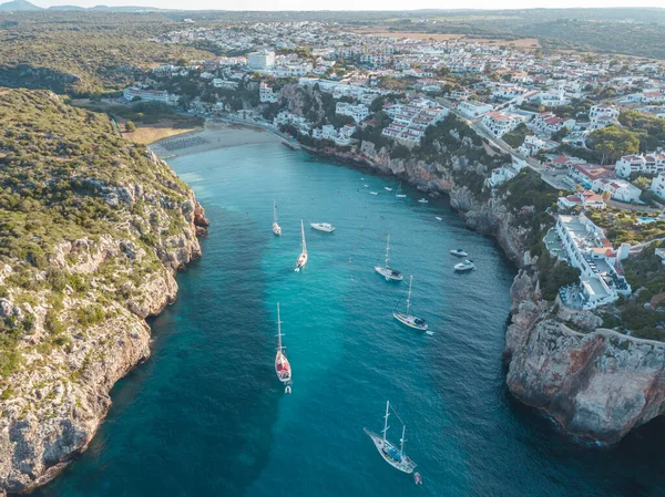 Akdeniz 'de turkuaz safirli sularla dolu tropikal plaja yanaşmış bir teknenin kuş bakışı dronu.