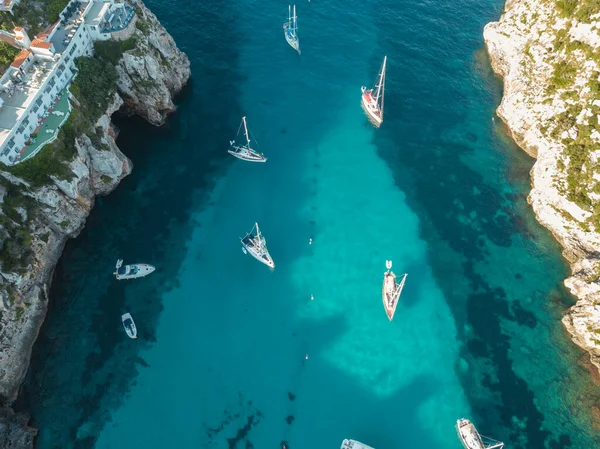 Akdeniz 'de turkuaz safirli sularla dolu tropikal plaja yanaşmış bir teknenin kuş bakışı dronu.