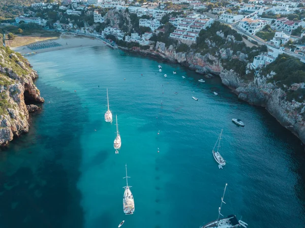 Akdeniz 'de turkuaz safirli sularla dolu tropikal plaja yanaşmış bir teknenin kuş bakışı dronu.