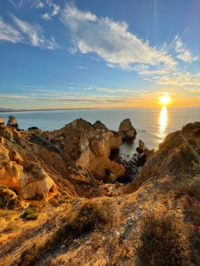 Praia Dona Ana Ponta da Piedade turkuaz deniz suyu ve uçurumları, Portekiz sahillerinde uçan martılar. Güzel Dona Ana Sahili (Praia Dona Ana) Lagos, Algarve, Portekiz.