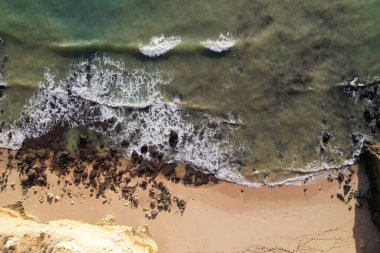 Kumsal ve dalgalar yukarıdan görünüyor. Turkuaz su arka planı. Havadan gelen yaz deniz manzarası. Portekiz Lagos Algarve. Seyahat konsepti ve fikri.