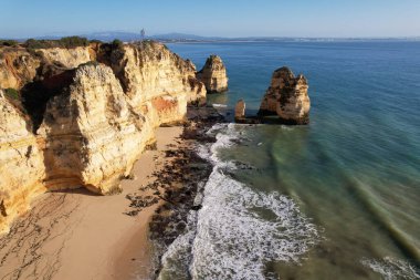 Kumsal ve dalgalar yukarıdan görünüyor. Turkuaz su arka planı. Havadan gelen yaz deniz manzarası. Portekiz Lagos Algarve. Seyahat konsepti ve fikri.