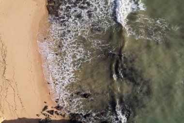 Kumsal ve dalgalar yukarıdan görünüyor. Turkuaz su arka planı. Havadan gelen yaz deniz manzarası. Portekiz Lagos Algarve. Seyahat konsepti ve fikri.
