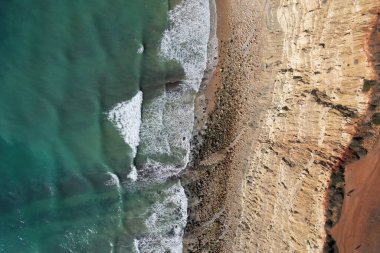 Kumsal ve dalgalar yukarıdan görünüyor. Turkuaz su arka planı. Havadan gelen yaz deniz manzarası. Portekiz Lagos Algarve. Seyahat konsepti ve fikri.