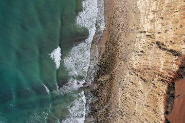 Kumsal ve dalgalar yukarıdan görünüyor. Turkuaz su arka planı. Havadan gelen yaz deniz manzarası. Portekiz Lagos Algarve. Seyahat konsepti ve fikri.