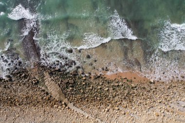 Kumsal ve dalgalar yukarıdan görünüyor. Turkuaz su arka planı. Havadan gelen yaz deniz manzarası. Portekiz Lagos Algarve. Seyahat konsepti ve fikri.
