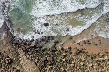Kumsal ve dalgalar yukarıdan görünüyor. Turkuaz su arka planı. Havadan gelen yaz deniz manzarası. Portekiz Lagos Algarve. Seyahat konsepti ve fikri.