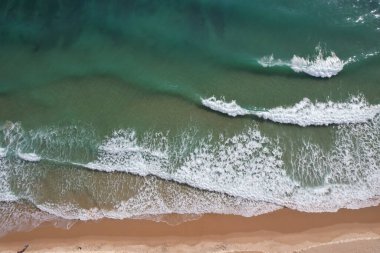Kumsal ve dalgalar yukarıdan görünüyor. Turkuaz su arka planı. Havadan gelen yaz deniz manzarası. Portekiz Lagos Algarve. Seyahat konsepti ve fikri.