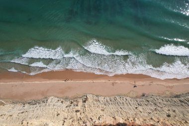 Kumsal ve dalgalar yukarıdan görünüyor. Turkuaz su arka planı. Havadan gelen yaz deniz manzarası. Portekiz Lagos Algarve. Seyahat konsepti ve fikri.