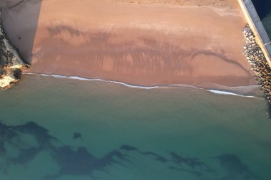Kumsal ve dalgalar yukarıdan görünüyor. Turkuaz su arka planı. Havadan gelen yaz deniz manzarası. Portekiz Lagos Algarve. Seyahat konsepti ve fikri.