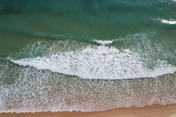 Kumsal ve dalgalar yukarıdan görünüyor. Turkuaz su arka planı. Havadan gelen yaz deniz manzarası. Portekiz Lagos Algarve. Seyahat konsepti ve fikri.