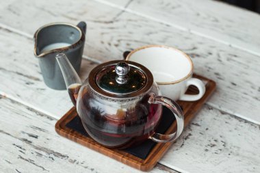 Kahve fincanda, kafenin ahşap masasında, ışıklandırma arka planında.