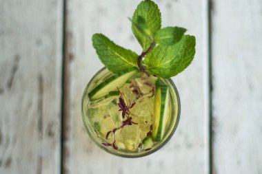 Alkol içki (cin tonik kokteyl) limon, biberiye ve rustik siyah taş tablo, kopya alanı, buza üst görünüm. Limonlu buzlu içecek.