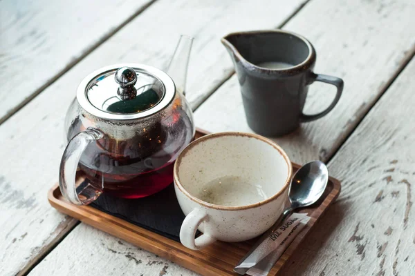 Kahve fincanda, kafenin ahşap masasında, ışıklandırma arka planında.