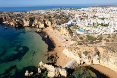 Ponta da Piedade, Portekiz, Algarve 'deki Lagos yakınlarında kayaların üzerinde. Ponta da Piedade, Algarve bölgesi, Portekiz. Plaj Turistleri Şemsiyeler