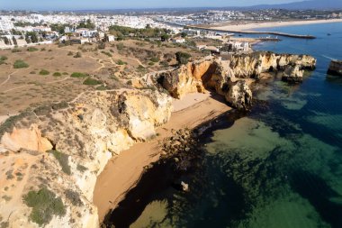 Ponta da Piedade, Portekiz, Algarve 'deki Lagos yakınlarında kayaların üzerinde. Ponta da Piedade, Algarve bölgesi, Portekiz. Plaj Turistleri Şemsiyeler