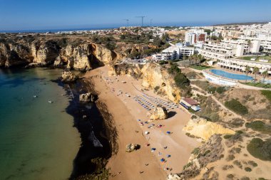Ponta da Piedade, Portekiz, Algarve 'deki Lagos yakınlarında kayaların üzerinde. Ponta da Piedade, Algarve bölgesi, Portekiz. Plaj Turistleri Şemsiyeler