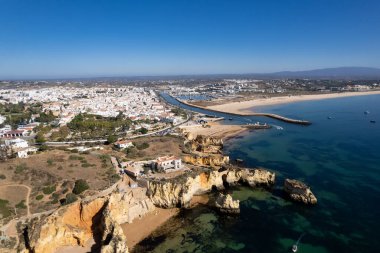 Ponta da Piedade, Portekiz, Algarve 'deki Lagos yakınlarında kayaların üzerinde. Ponta da Piedade, Algarve bölgesi, Portekiz. Plaj Turistleri Şemsiyeler