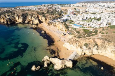 Ponta da Piedade, Portekiz, Algarve 'deki Lagos yakınlarında kayaların üzerinde. Ponta da Piedade, Algarve bölgesi, Portekiz. Plaj Turistleri Şemsiyeler