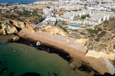 Ponta da Piedade, Portekiz, Algarve 'deki Lagos yakınlarında kayaların üzerinde. Ponta da Piedade, Algarve bölgesi, Portekiz. Plaj Turistleri Şemsiyeler