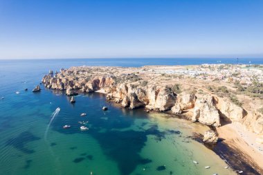 Ponta da Piedade, Portekiz, Algarve 'deki Lagos yakınlarında kayaların üzerinde. Ponta da Piedade, Algarve bölgesi, Portekiz. Plaj Turistleri Şemsiyeler