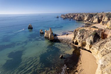 Ponta da Piedade, Portekiz, Algarve 'deki Lagos yakınlarında kayaların üzerinde. Ponta da Piedade, Algarve bölgesi, Portekiz. Plaj Turistleri Şemsiyeler