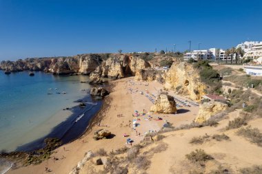 Ponta da Piedade, Portekiz, Algarve 'deki Lagos yakınlarında kayaların üzerinde. Ponta da Piedade, Algarve bölgesi, Portekiz. Plaj Turistleri Şemsiyeler