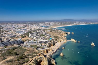 Ponta da Piedade, Portekiz, Algarve 'deki Lagos yakınlarında kayaların üzerinde. Ponta da Piedade, Algarve bölgesi, Portekiz. Plaj Turistleri Şemsiyeler