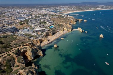 Ponta da Piedade, Portekiz, Algarve 'deki Lagos yakınlarında kayaların üzerinde. Ponta da Piedade, Algarve bölgesi, Portekiz. Plaj Turistleri Şemsiyeler