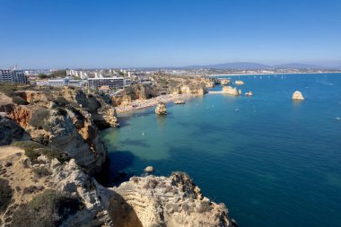 Ponta da Piedade, Portekiz, Algarve 'deki Lagos yakınlarında kayaların üzerinde. Ponta da Piedade, Algarve bölgesi, Portekiz. Plaj Turistleri Şemsiyeler