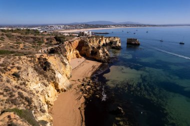 Ponta da Piedade, Portekiz, Algarve 'deki Lagos yakınlarında kayaların üzerinde. Ponta da Piedade, Algarve bölgesi, Portekiz. Plaj Turistleri Şemsiyeler