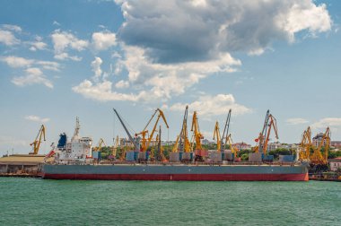 Vinçler limandaki gemiden yük yükler.