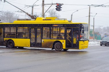 Poltava, Ukrayna. Aralık 06.2021. Sarı troleybüs terminalde geri dönüyor, kar yağıyor.