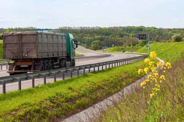 Expressway with multi-lane traffic, road bends with up and down slopes. Lorry close-up driving along the European bypass highway — Foto de Stock