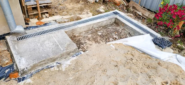 Kanalizasyonlu beton kör alan üretimi. Metal ızgaralı beton tepsiler. Jeotextiles için kum yastığı. Bahçe düzenleme işi — Stok fotoğraf
