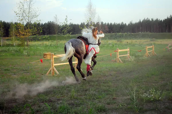 Kyiv, Ukrayna. 6 Temmuz 2013. Atın dört nala koşması, binici kadının jimnastik numaraları. Tarih parkında programı göster.
