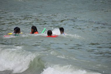 Toco, Trinidad ve Tobago- 28 Mart 2022 - Plaja gidenler, Karayipler 'in Trinidad adasının kuzey doğu kıyısındaki bir kıyı bölgesi olan Toco' daki Saline Bay 'de Sabah Sahil Banyosunun tadını çıkarıyorlar.