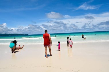 Boracay Island, Philippines, July 10, 2022, happy family, Father and kids playing in white sand beach.