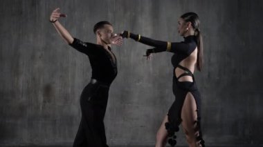 Genç, zarif bir kız ve erkek balo salonu çifti, siyah elbiseli, tango yapan, şehvetli bir şekilde dans ediyorlar. Profesyonel dansçılar Latin dansçıları canlandırır. İnsani duygular, aşk ve tutku