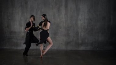 Genç, zarif bir kız ve erkek balo salonu çifti, siyah elbiseli, tango yapan, şehvetli bir şekilde dans ediyorlar. Profesyonel dansçılar Latin dansçıları canlandırır. İnsani duygular, aşk ve tutku