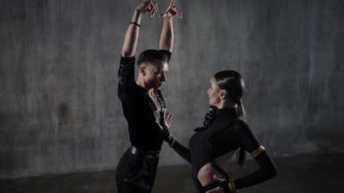 Genç, zarif bir kız ve erkek balo salonu çifti, siyah elbiseli, tango yapan, şehvetli bir şekilde dans ediyorlar. Profesyonel dansçılar Latin dansçıları canlandırır. İnsani duygular, aşk ve tutku