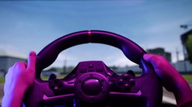 Bilgisayarda simülatör oyunu oynayan küçük çocuk. Çocuk direksiyonlu playstation oyunu kullanıyor. Çocuk evde video kontrolörüyle araba yarışı simülatörü oynuyor, konsept sürmeyi öğreniyor.