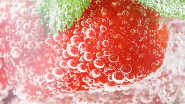 Koude verfrissende aardbeienlimonade of mojito cocktail met ijsblokjes en verse muntblaadjes. Berry plakjes in bruisende sprankelende tonic met bubbels, sap verfrissing koolzuurhoudende frisdrank of drank — Stockvideo